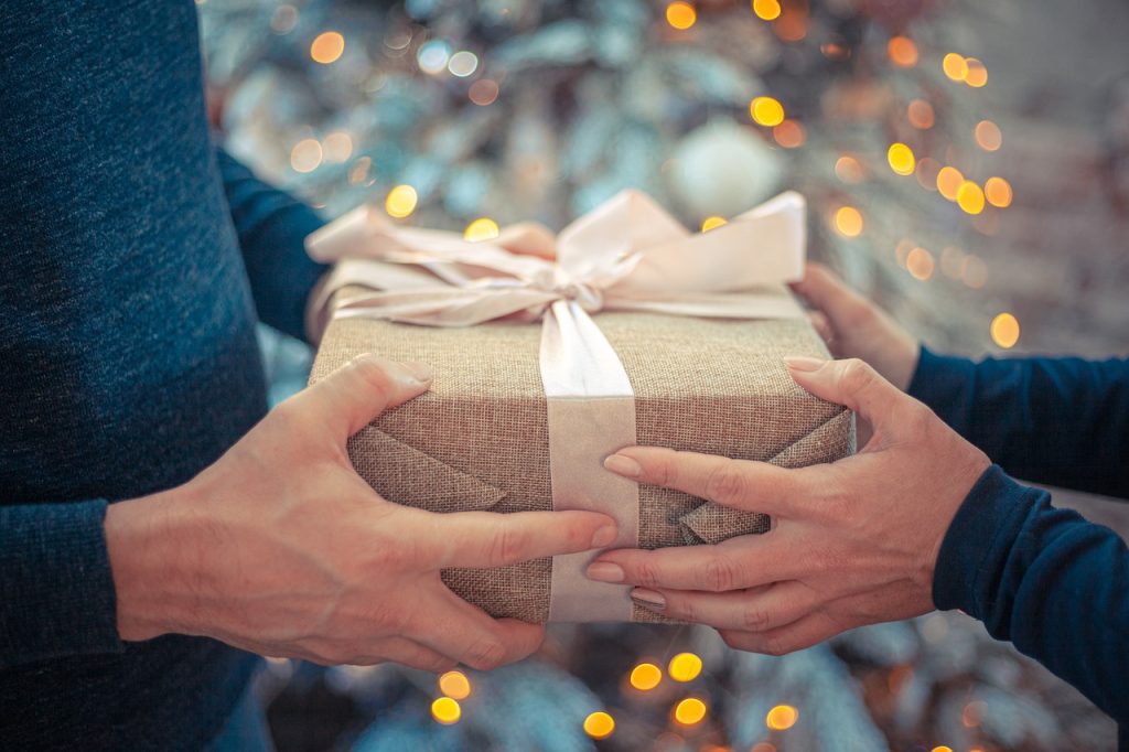 80+ ideas for holiday gifts for guys--Image of a man and woman holding a present