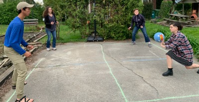 Adult kids: Image of mother with three adult kids playing four square. 