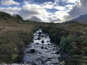 An image in Scotland with a rocky stream, pasture, and gorgeous sky.