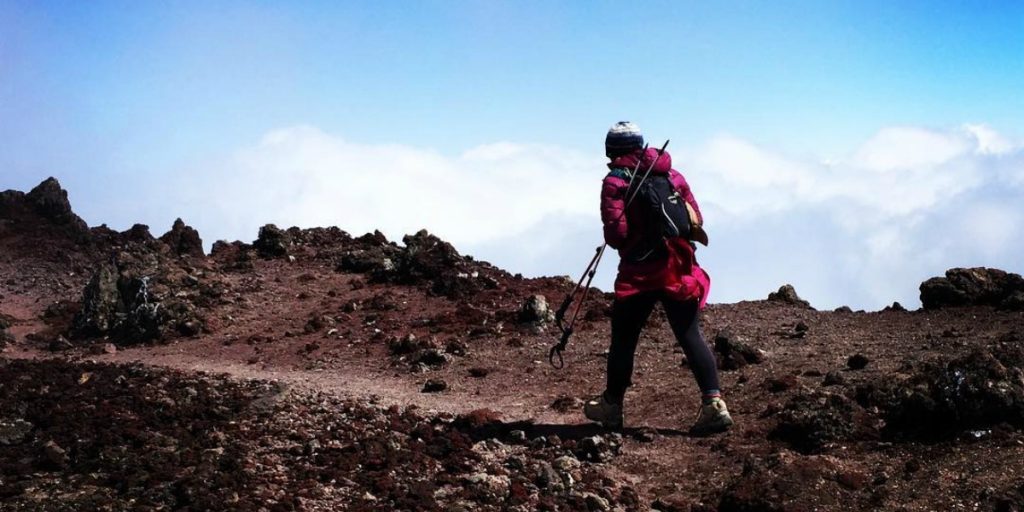(Breast) Cancer: An Insider's Account: image of a woman hiking with expedition poles.