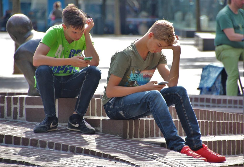 Sextortion 101: What you (and your kids) need to know--image of two teen boys on cell phones