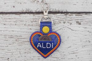 The 26 Best Things at Aldi post: image of Aldi heartshaped keychain with pouch for a cart quarter.